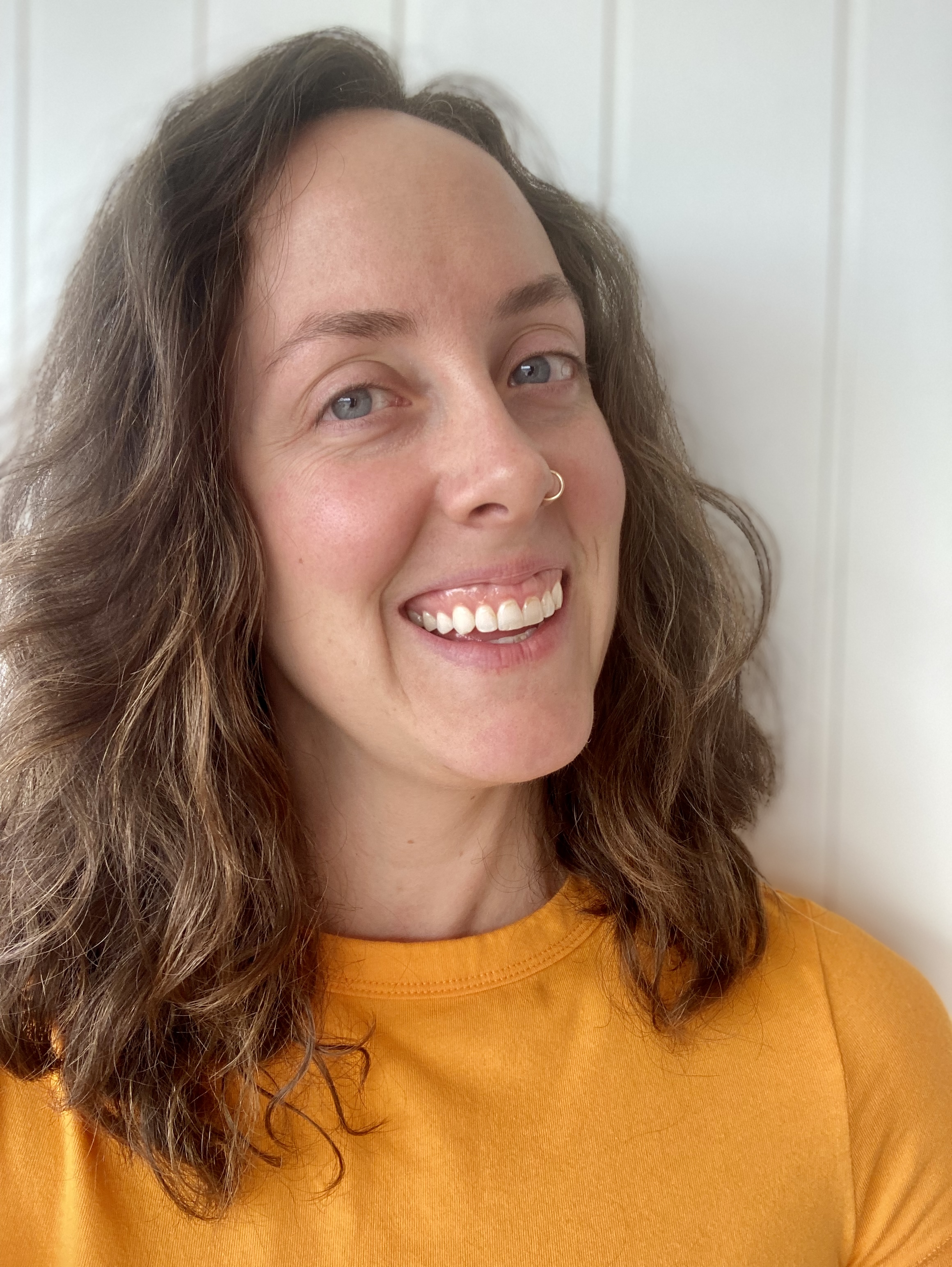 woman smiling in orange shirt